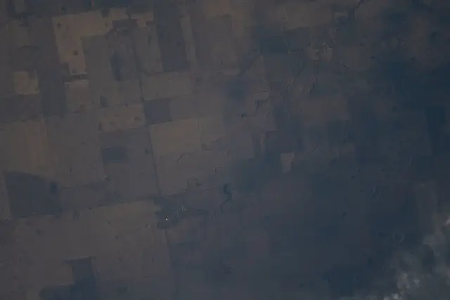 Aerial view of farmland and Peebles from space